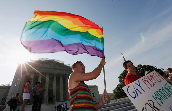 Een actievoerder voor homorechten staat met de Regenboogvlag voor het gebouw van het Hooggerechtshof in Washington DC