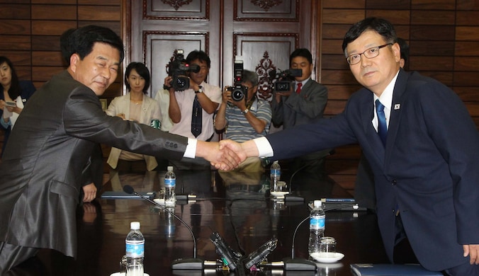 Suh Ho van Zuid-Korea schudt handjes met Park Chol-Su van Noord-Korea.
