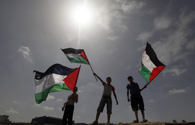 Palestijnse jongens zwaaien met vlaggen.