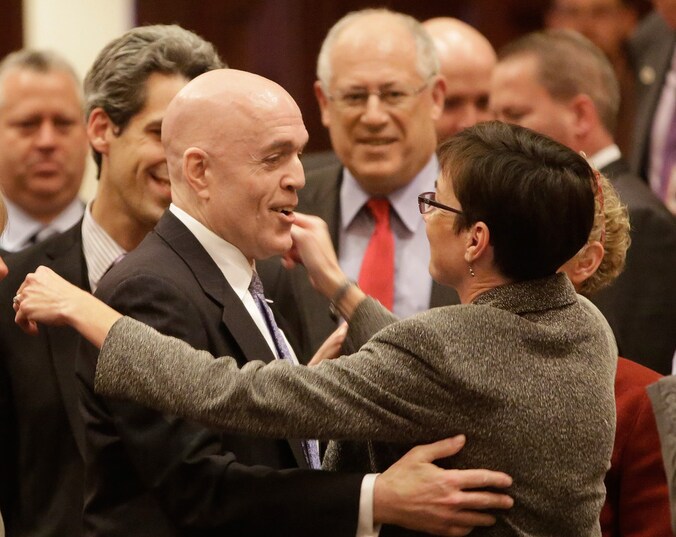 De Democratische Afgevaardigde Greg Harris (links) wordt gefeliciteerd nadat het Huis van Afgevaardigden in Illinois heeft ingestemd met het homohuwelijk.