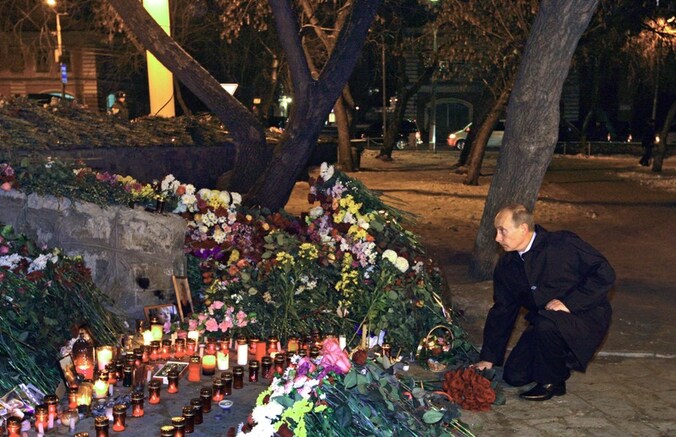 Poetin legt bloemen neer voor de slachtoffers in Perm.