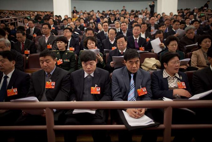Afgevaardigden van de Communistische Partij zitten klaar in de Grote Hal van het Volk.