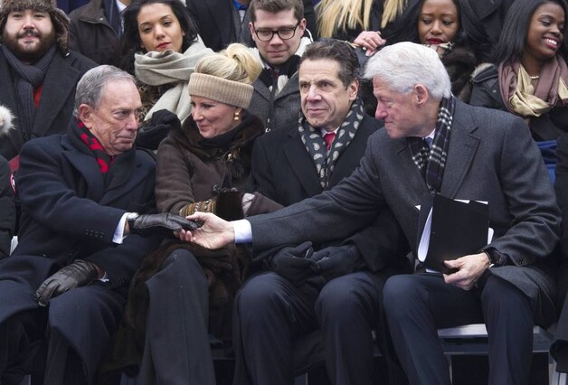 Bill Clinton schudt de hand van voormalig burgemeester van New York Michael Bloomberg (links).
