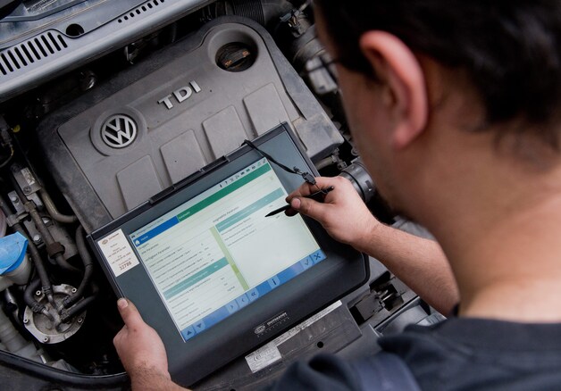 Een automecanicien analiseert de resultaten van een motortest.