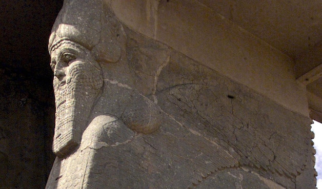 Een beeld van een gevleugelde stier met een menselijk hoofd in Nimrud.