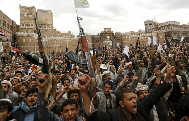 Sjiitische rebellen zwaaien met hun wapens tijdens een betoging tegen de luchtaanvallen in Sanaa.