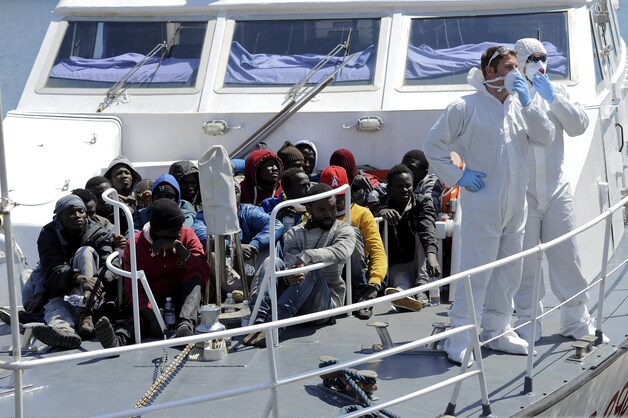 Vluchtelingen aan boord van een reddingsschip voor de kust van Sicilië.