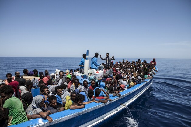 Vluchtelingen wachten in een volgepropte houten boot voor de kust van Malta op redding.