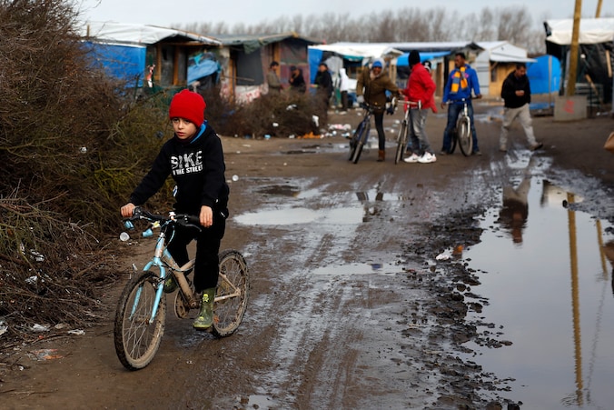 Kinderen fietsen in The Jungle van Calais.