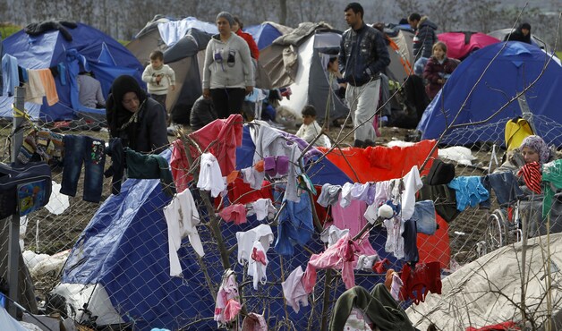 Vluchtelingen in een geïmproviseerd kamp op de grens tussen Macedonië en Servië.