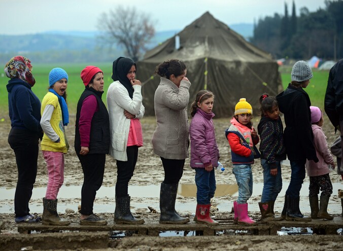 Vluchtelingen staan in de rij voor thee in het kamp op de Grieks-Macedonische grens in Idomeni.