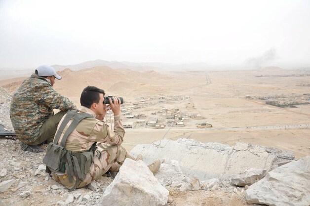 De Syrische pro-regeringstroepen kijken over de stad Palmyra uit.