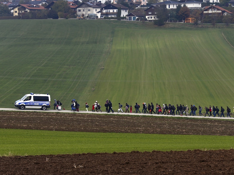 Migranten worden door de Duitse politie naar een registratiecentrum geëscorteerd nadat ze de Oostenrijks-Duitse grens overstaken in Wegscheid in oktober vorig jaar.