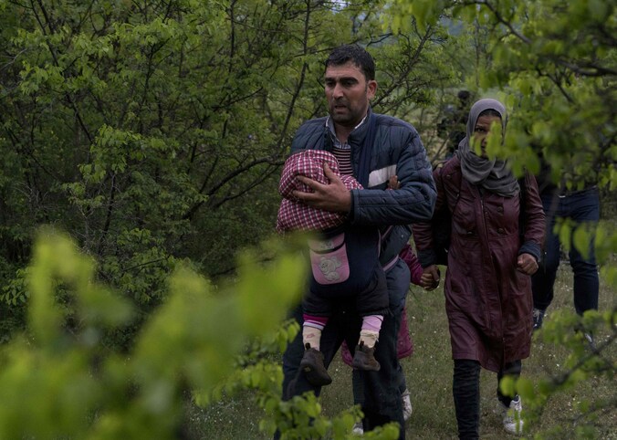 Syrische vluchtelingen steken illegaal de grens over tussen Macedonië en Griekenland.