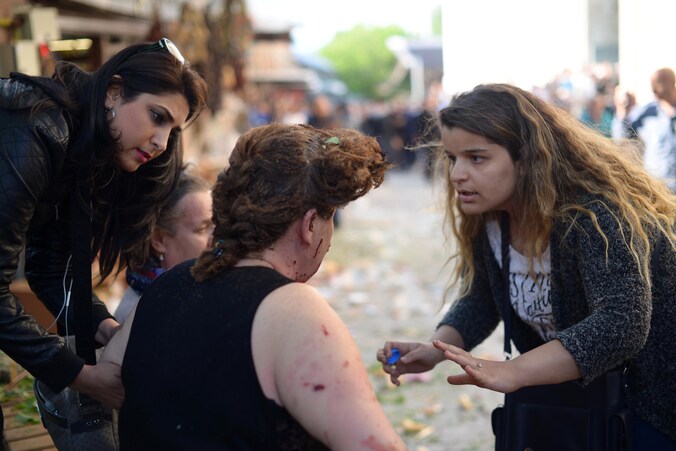 Vrouw geeft verzorging aan een gewonde na de aanslagen in Bursa.