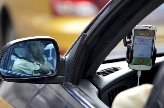Een Chinese taxichauffeur gebruikt de Didi Chuxing-app.