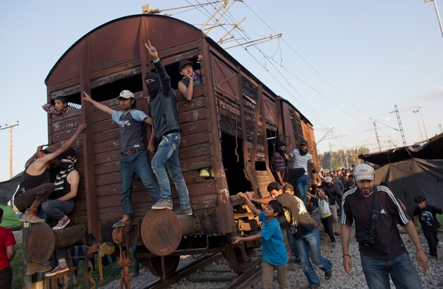 Migranten duwen een treinwagen naar het politiekordon.