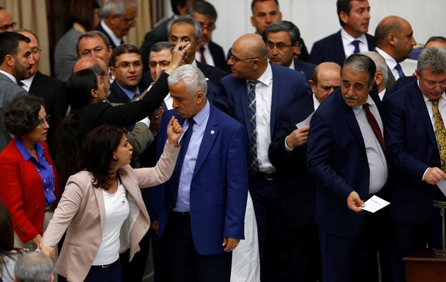 AK-parlementsleden (rechts) stemmen voor het wetsvoorstel dat Erdogan meer macht geeft, tot ongenoegen van de HDP-oppositie(links).