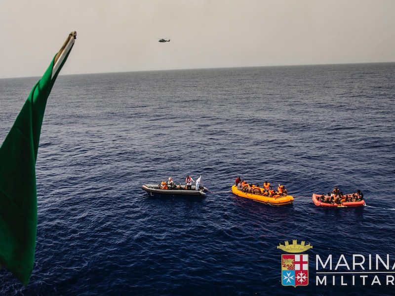 Foto van de Italiaanse kustwacht die boten met migranten oppikt voor de Libische kust.