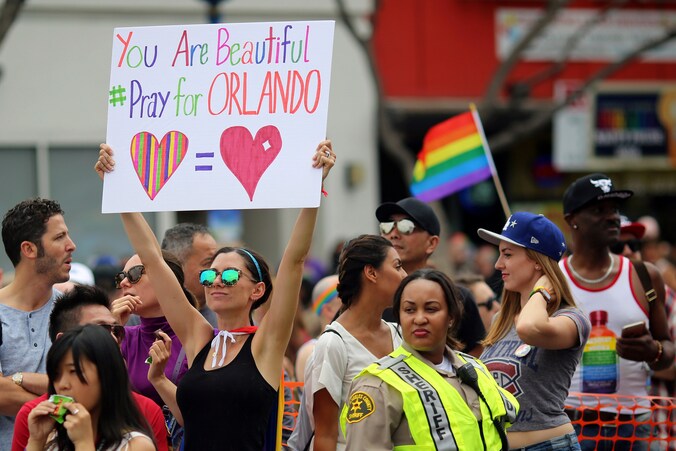 Een jonge vrouw houdt op de Gay Parade van Los Angeles een bord omhoog.