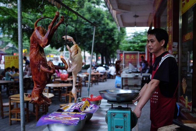 Een Chinese chef wacht bij zijn restaurant in Yulin op klanten.