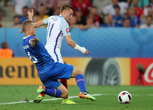 Kenmerkend voor de IJslandse grinta: Sigurdsson gooit alles in de strijd om Vardy het scoren te beletten. Met succes.