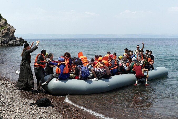 Een Grieks-orthodoxe priester verwelkomt vluchtelingen op het Griekse eiland Lesbos.