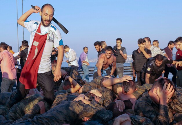 Op foto's is te zien dat de soldaten op de Bosporusbrug hardhandig aangepakt worden.