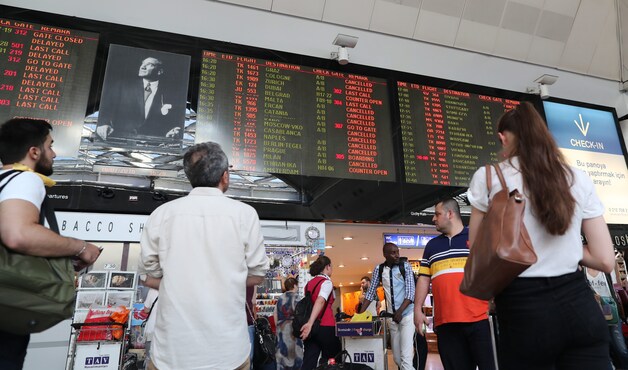 Passagiers op de luchthaven Ataturk kijken naar de vertrekkende vluchten