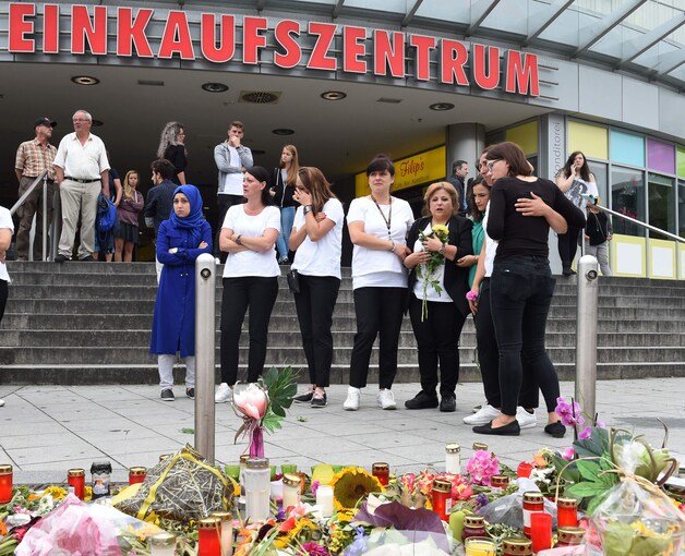 Bloemen aan het winkelcentrum in München waar de 18-jarige Ali David Sonboly zaterdag negen,vooral jonge, mensen doodschoot.