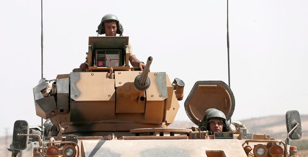 Turkse militairen in een tank op weg naar Syrië.