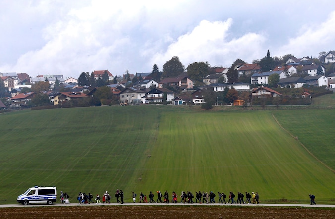 De Duitse politie escorteert migranten naar een registratiecentrum nadat ze de Oostenrijks-Duitse grens hebben overgestoken in Wegscheid, nabij Passau.