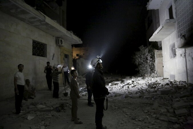 Inwoners en reddingswerkers inspecteren vernielde gebouwen in Maaret al-Numan.