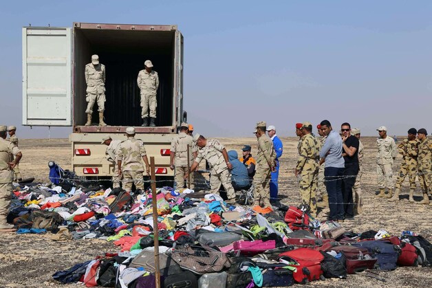 Egyptisch en Russisch veiligheidspersoneel bij teruggevonden bezittingen van de 224 omgekomen passagiers.