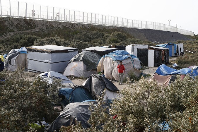 Een deel van het vluchtelingenkamp in Calais met op de achtergrond de bypass naar de haven.