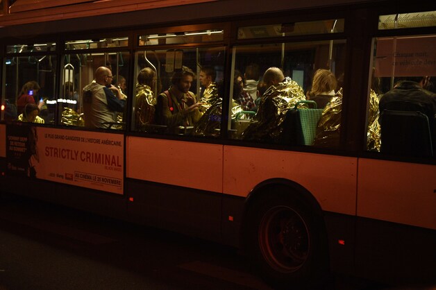 Concertgangers die de aanslag in de Bataclan hebben overleefd, worden in bussen weggebracht.