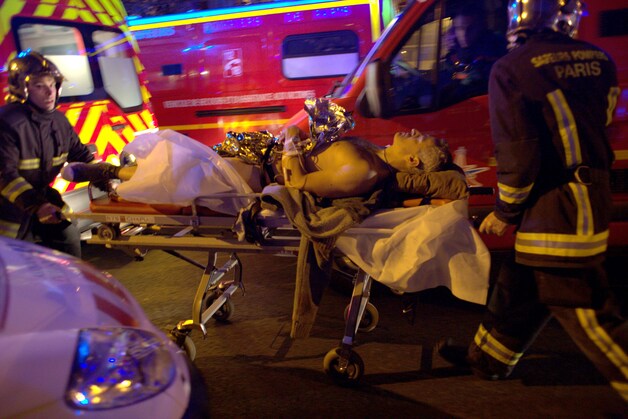 Een gewonde wordt na het bloedbad in de concertzaal Bataclan weggebracht.