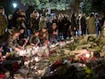 Mensen leggen bloemen en plaatsen kaarsen aan de Bataclan in Parijs als eerbetoon aan de slachtoffers van de aanvallen op vrijdag 13 november.