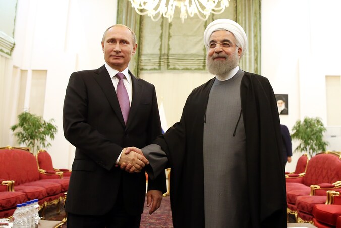 Russisch president Vladimir Poetin schudt Iraans president Hassan Rouhani de hand tijdens een top van gasexporterende landen in november vorig jaar.