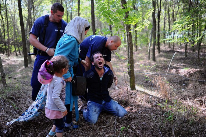 De vader van een migrantengezin wordt nabij de Hongaars-Servische grens gearresteerd, in augustus 2015.