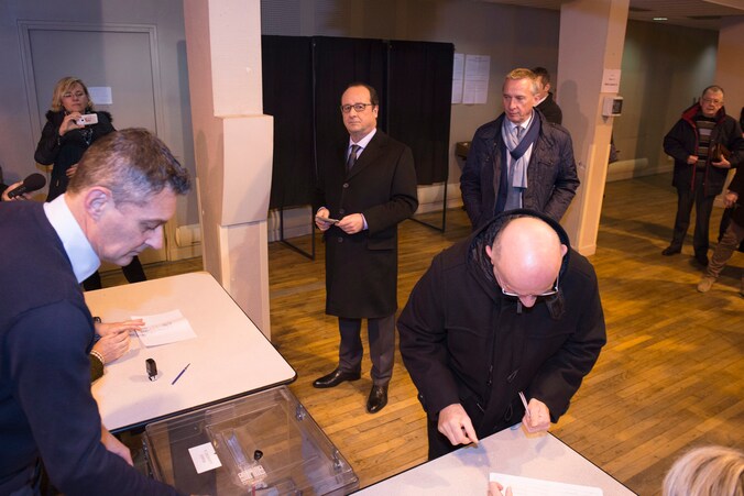 President François Hollande schuift aan om zijn stem uit te brengen.