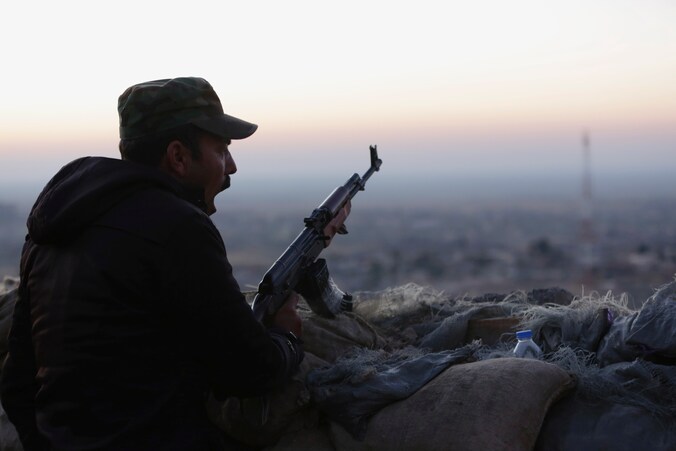 Een peshmerga-strijder kijkt uit over een gebied in Sinjar.