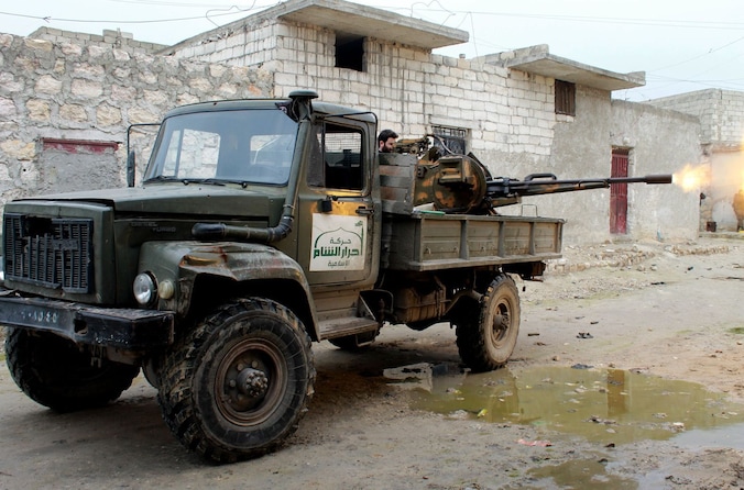 Een lid van rebellengroep Ahrar al-Sham bedient een machinegeweer in Aleppo.