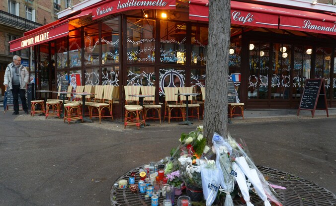 Voor een van de getroffen restaurants in Parijs liggen bloemen.