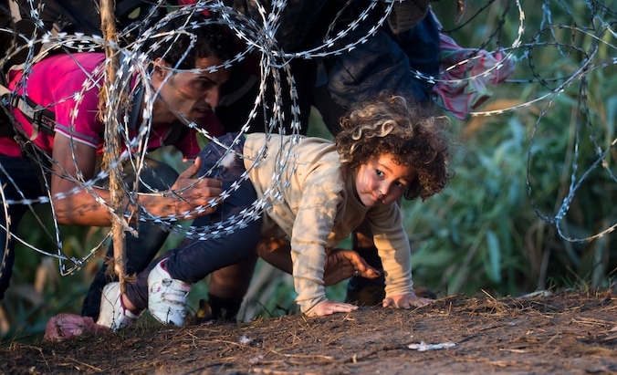 Vluchtelingen steken de grens tussen Servië en Hongarije over, archiefbeeld van augustus 2015.