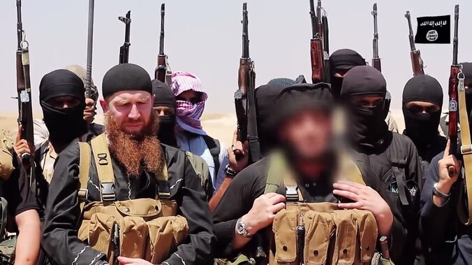 Abu Omar al-Shishani, met rode baard, tussen andere extremisten van IS.