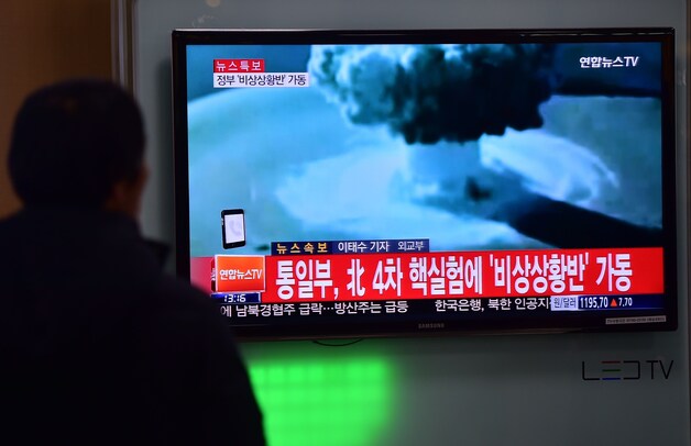 Een Zuid-Koreaan kijkt op televisie naar een reportage over de explosie.