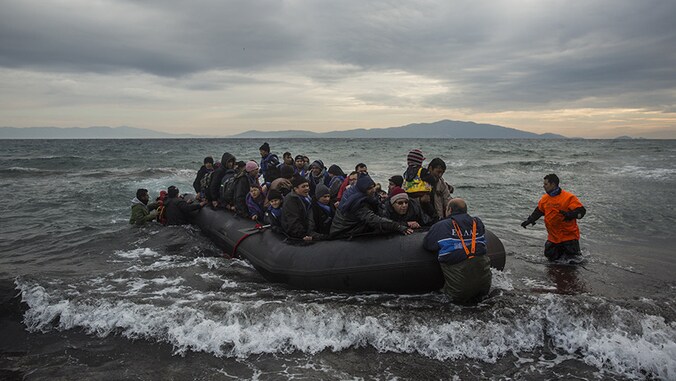 Een rubberboot propvol vluchtelingen komt aan op het strand van Lesbos
