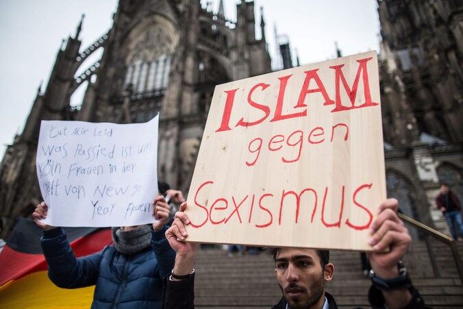 Een Syriër houdt een bord omhoog waarin hij afstand neemt van de aanrandingen in Keulen.