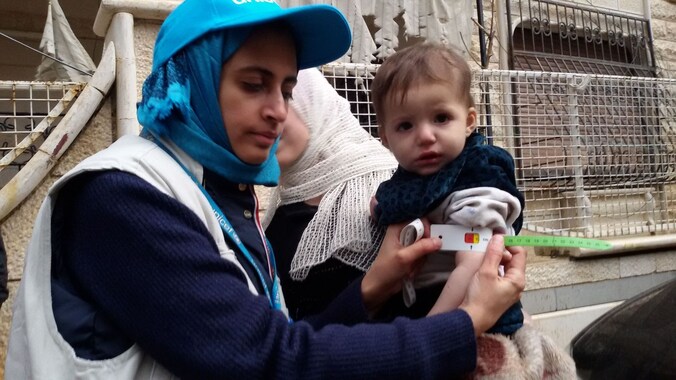 Een UNICEF-medewerker meet de armomtrek van een kind in Madaya om te kijken of hij ondervoed is. Volgens één hulpverlener geven ouders hun kinderen slaappillen om het hongergevoel te onderdrukken.